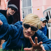Artist kula shaker lying on grass